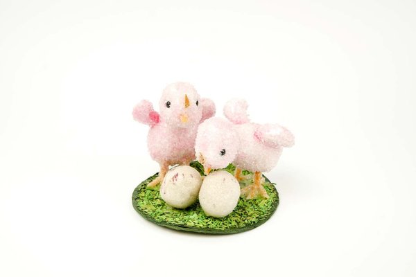 Osterküken mit Eiern auf Oster-Gras rosa Küken